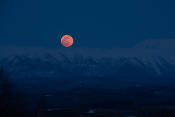 春の月の出　十勝岳連峰