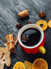 Mulled wine with spice and orange on wooden background with autumn leaves