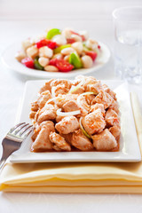Turkey stew in tomato mustard sauce with onion on square plate