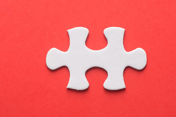 Obraz premium Unfinished white jigsaw puzzle pieces on red background