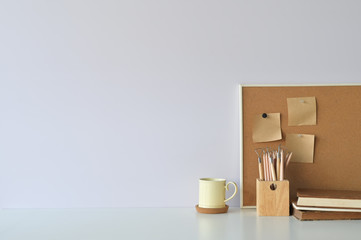 Office workspace coffee, pencil, books and sticky note on board with copy space.