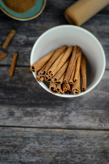 Ground cinnamon, cinnamon sticks and powder on old wooden background in rustic style