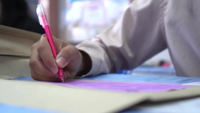 Document Report and Education Concept: Teacher woman hands holding pen for checking signing and note on white documents reports papers of paper files in meeting seminar room background.  