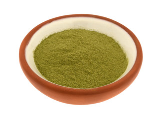 Side view of organic powdered wheat grass in a small bowl