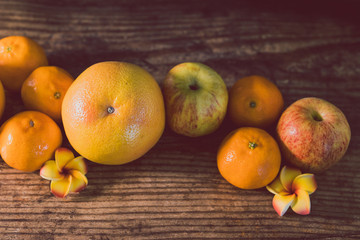 healthy fruit including oranges grapefruit and apples on dark wooden surface