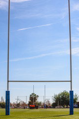 Background of a rugby goal casting shadows on the field.