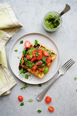 Vegetable waffles with pesto and tomatoes
