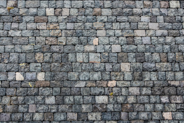Fototapeta premium A beautiful horizontal texture of part of an old gray brick wall from frozen volcanic lava from Etna volcano in Sicily in Italy on the photo