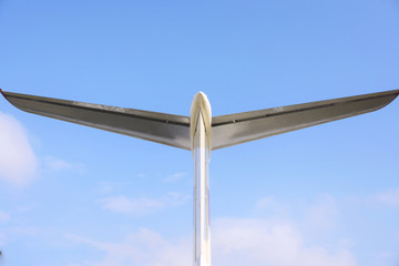 The steel silver back of a plane on blue sky background with empty space for text. Part of retro...