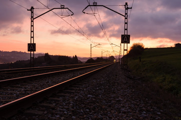 Fototapeta na wymiar Railway station against beautiful sky at sunset. Industrial landscape with railroad, colorful blue sky with red clouds, sun