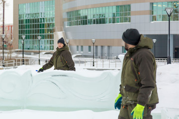 Assembler in overalls on the territory of the ice town