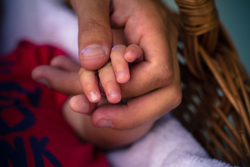 Father's hand holding child's little hand parenting concept