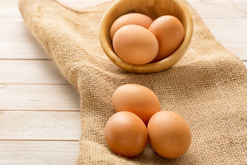 Bowl with egs on white wooden background