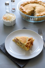 Slice of homemade sauerkraut pie on gray wooden table. Cabbage cake tradition russian food