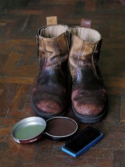 Vintage shoes on wooden floor, shoe polish and brush