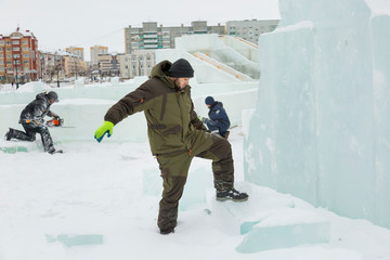 Fototapeta na wymiar Assembler in overalls on the territory of the ice town