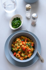 Healhty vegan bowl with quinoa, pumpkin, pepper and carrot on gray wooden background. Selective focus
