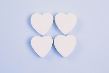 Four white heart on a pastel blue background. Love concept for your design.
