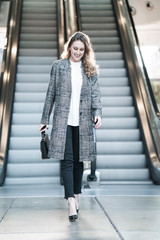 Hübsche junge Frau lächen fröhlich streetstyle lifestyle business Rollstreppe walk
