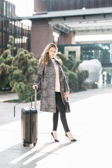 Schöne junge Frau freudig mit Koffer auf dem Weg zum Urlaub Business Trip lifestyle