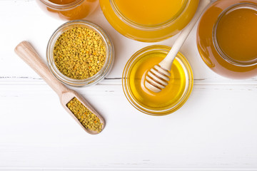 Honey with wooden honey dipper on wooden table