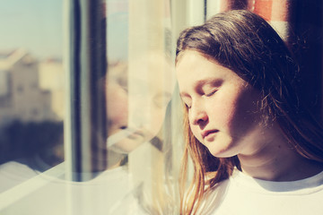 attractive sad teenage girl looking out of the window