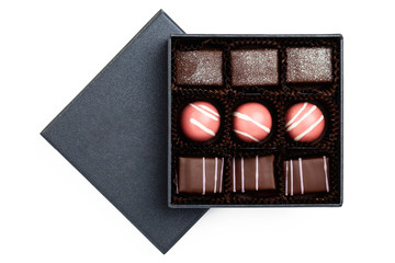 Assortment of luxury bonbons in black box isolated on white background