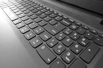 Zbliżenie na klawiaturę laptopa z widocznym klawiszem enter. Praca w biurze