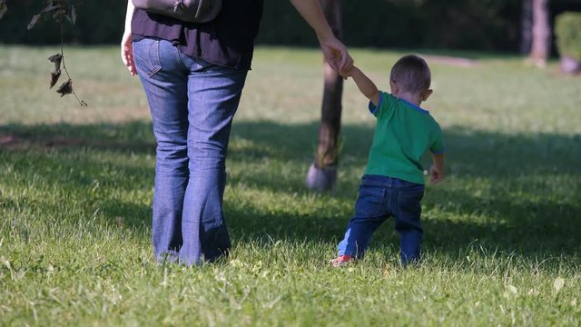 Baby holding mother hand, child pull parent hand to walk in his direction