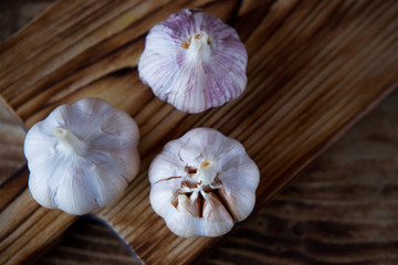Garlic lies on a wooden chopping Board.