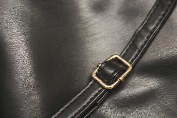 strip of black leather with straps for adjusting