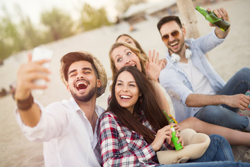 Group of cheerful friends having great time at beach