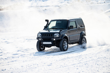 Fototapeta na wymiar Black SUV rally race at frozen river in winter