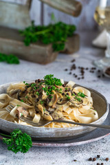 Pasta tagliatelle and mushrooms in creamy sauce with brandy and peppercorns