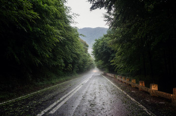 Obraz premium Car approaching through the fog after a powerful hale storm on Transfagarasan road, Transylvania, Romania