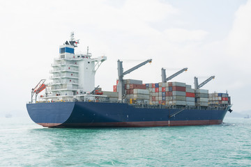 Fototapeta premium Container ship sailing calm waters in mid day