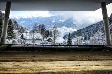 Wooden desk of free space and big window of mountains landscape. 