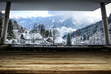 Wooden desk of free space and big window of mountains landscape. 