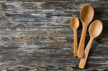 Culinary background with rustic spoons on vintage wooden table.