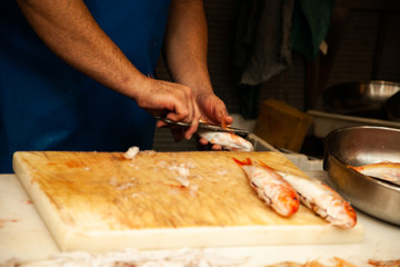 Men clean a fish