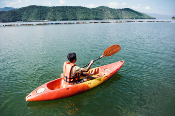 Fototapeta na wymiar man kayaking in dam river with mountain landscape view