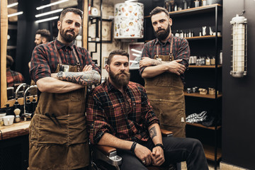 Hipster young good looking man at barber shop and hairstylist. Trendy and stylish beard styling and hair cut. - obrazy, fototapety, plakaty