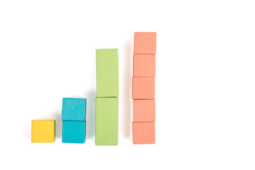 Toy wooden blocks as financial graph. Graph with four 4 steps. Growing chart. Infographic diagram, chart over grey or black or dark background. Multi-colored wooden blocks.
