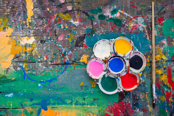 Palette with brushes on table wood background in a composition top view