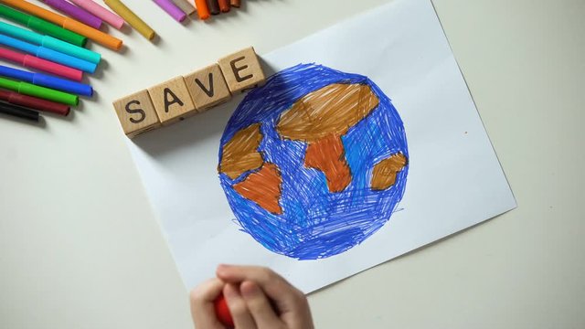 Child putting save word and heart sign on planet painting, ecology concept
