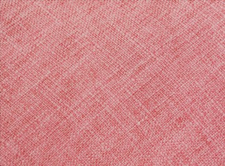 coral color on fabric, with visible texture. close up of a trendy colored background with copy space. 