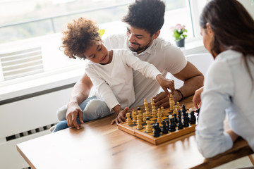 Happy family playing chess together - Powered by Adobe