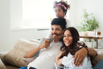 Family watches movie while sitting on the couch