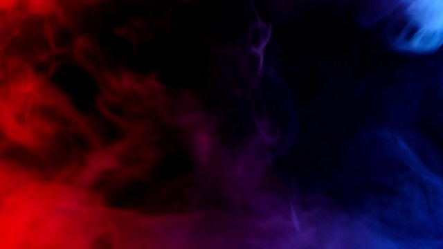 red and blue smoke patterns moving against at dark background
