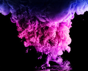 colored acrylic paint in water. the explosion of colours on a black background
